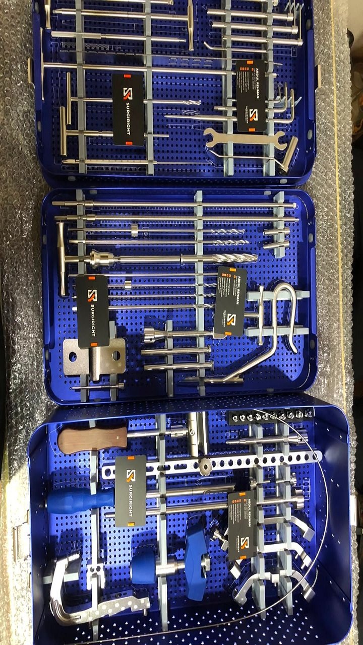 Three blue anodized surgical sterilization trays filled with stainless steel orthopedic tools and instruments by Surgiright